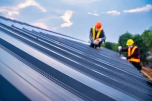 Technicians work on installing a roofing system.