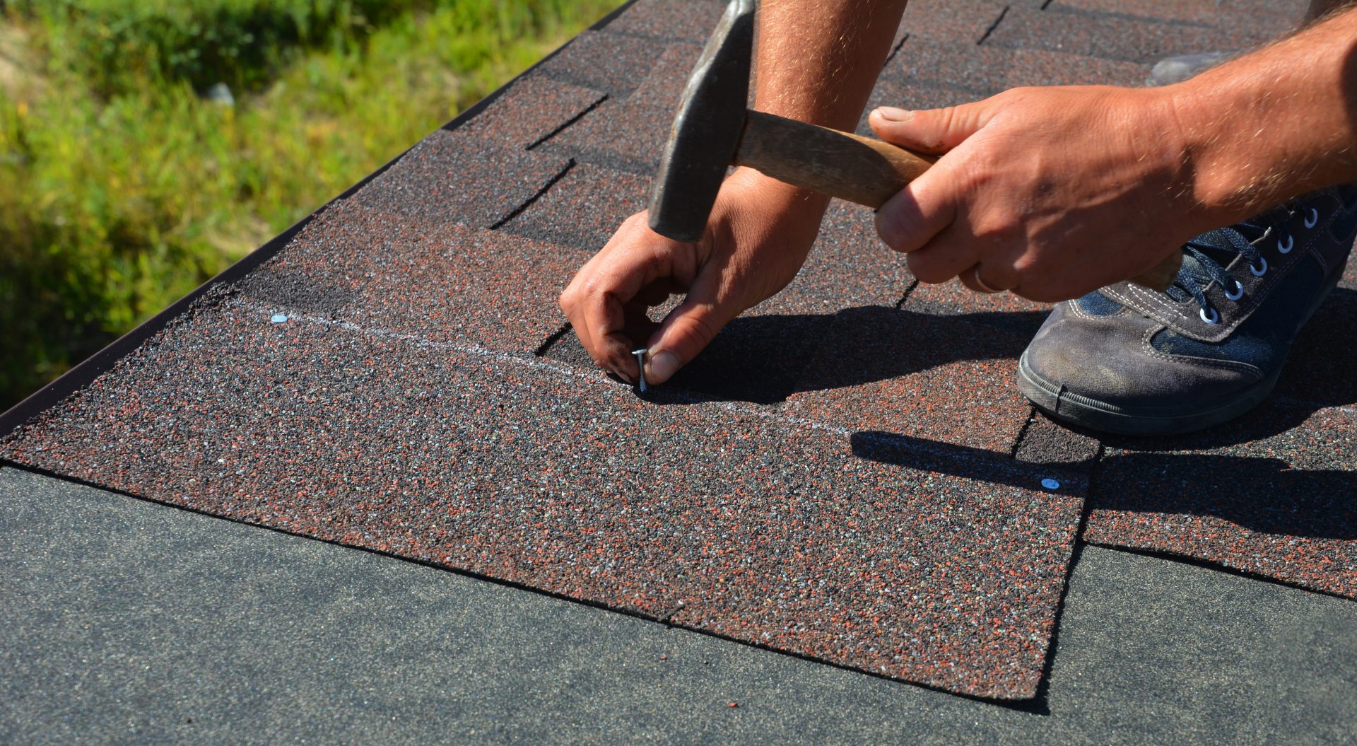 Picture of a roofing technician installing asphalt shingle roofing.