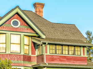 Residential home with red siding and a brown roof.