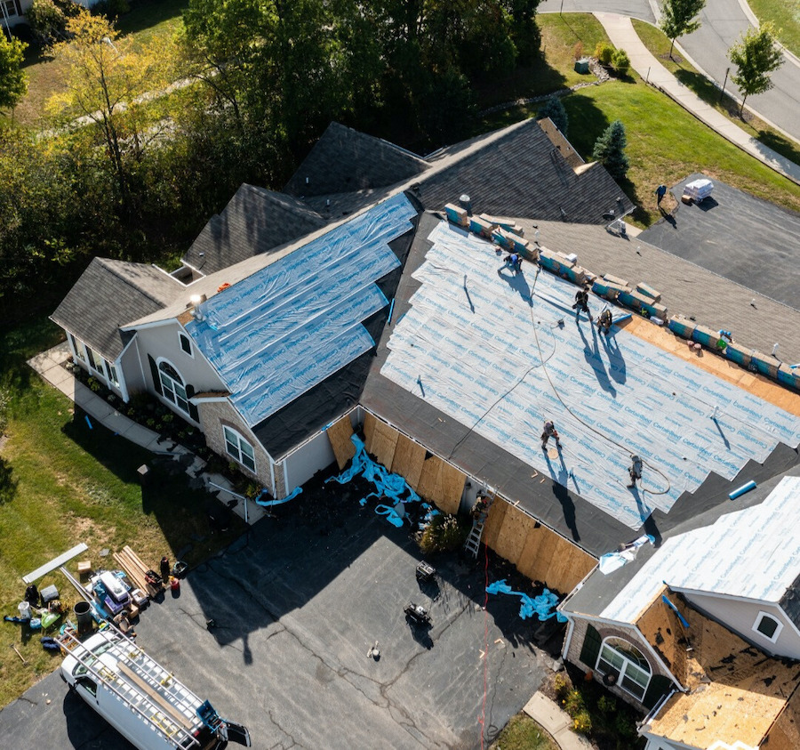 Roofing crew installing asphalt shingles on residential home
